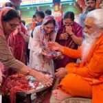 महिला श्रधालुओं को धागा वितरित करते हुए महंत शंकरपुरी
