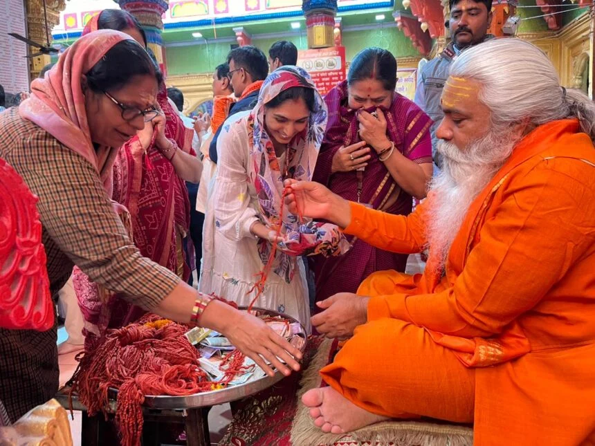 महिला श्रधालुओं को धागा वितरित करते हुए महंत शंकरपुरी