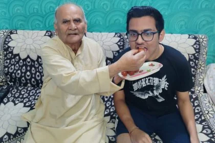 फोटो आयुष राज को मिठाई खिलाते हुए दादा देवनाथ तिवारी।