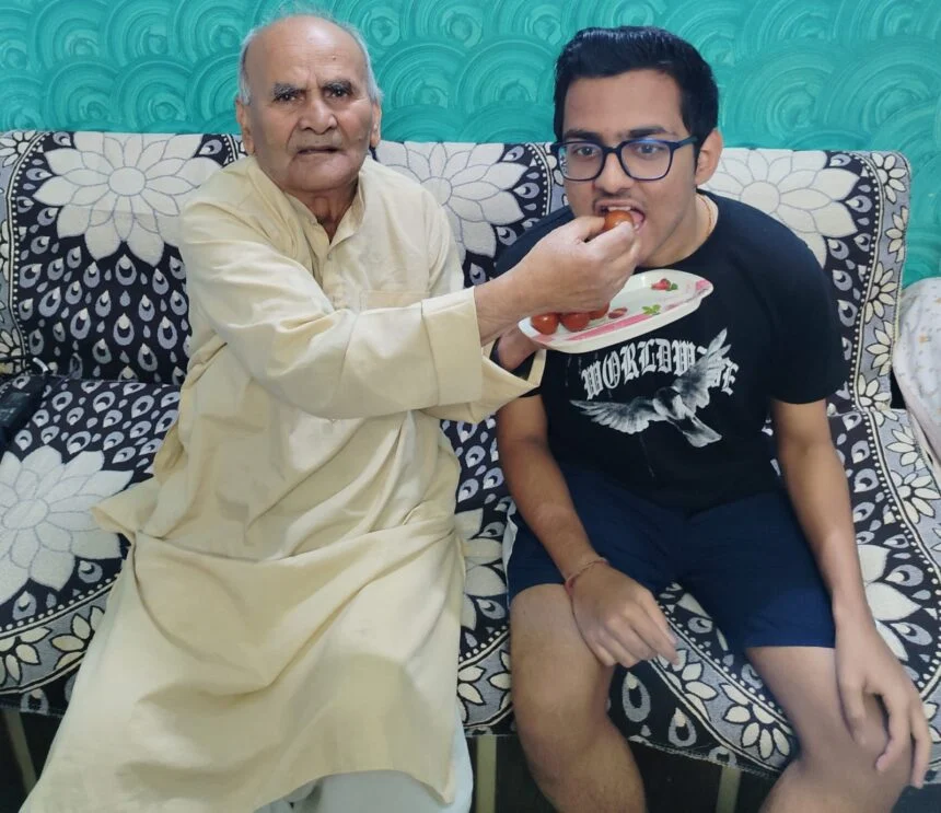 फोटो आयुष राज को मिठाई खिलाते हुए दादा देवनाथ तिवारी।